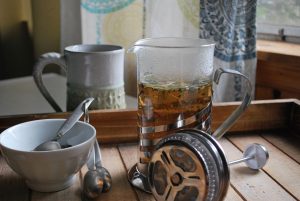 Using a French press to make herbal tea.